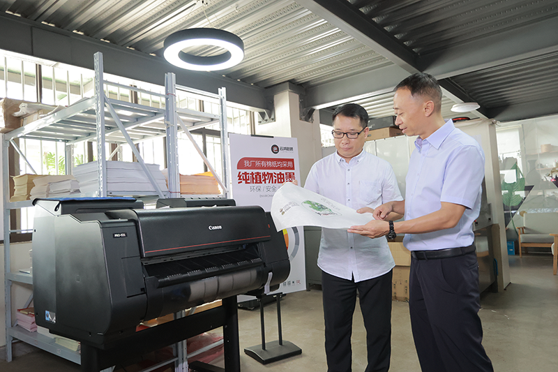 汤哲晶（右）为客户展示佳能设备的打印性能